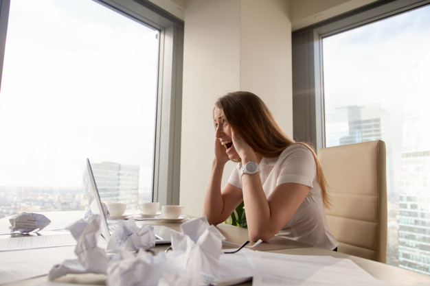 Stressed businesswoman screaming at workplace
