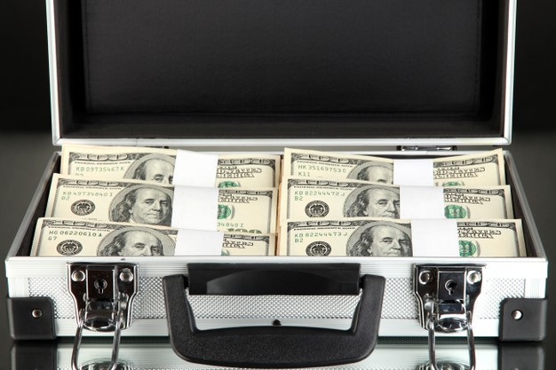 Suitcase with 100 dollar bills on black