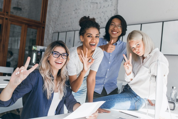 Two blonde female office workers posing with peace sign